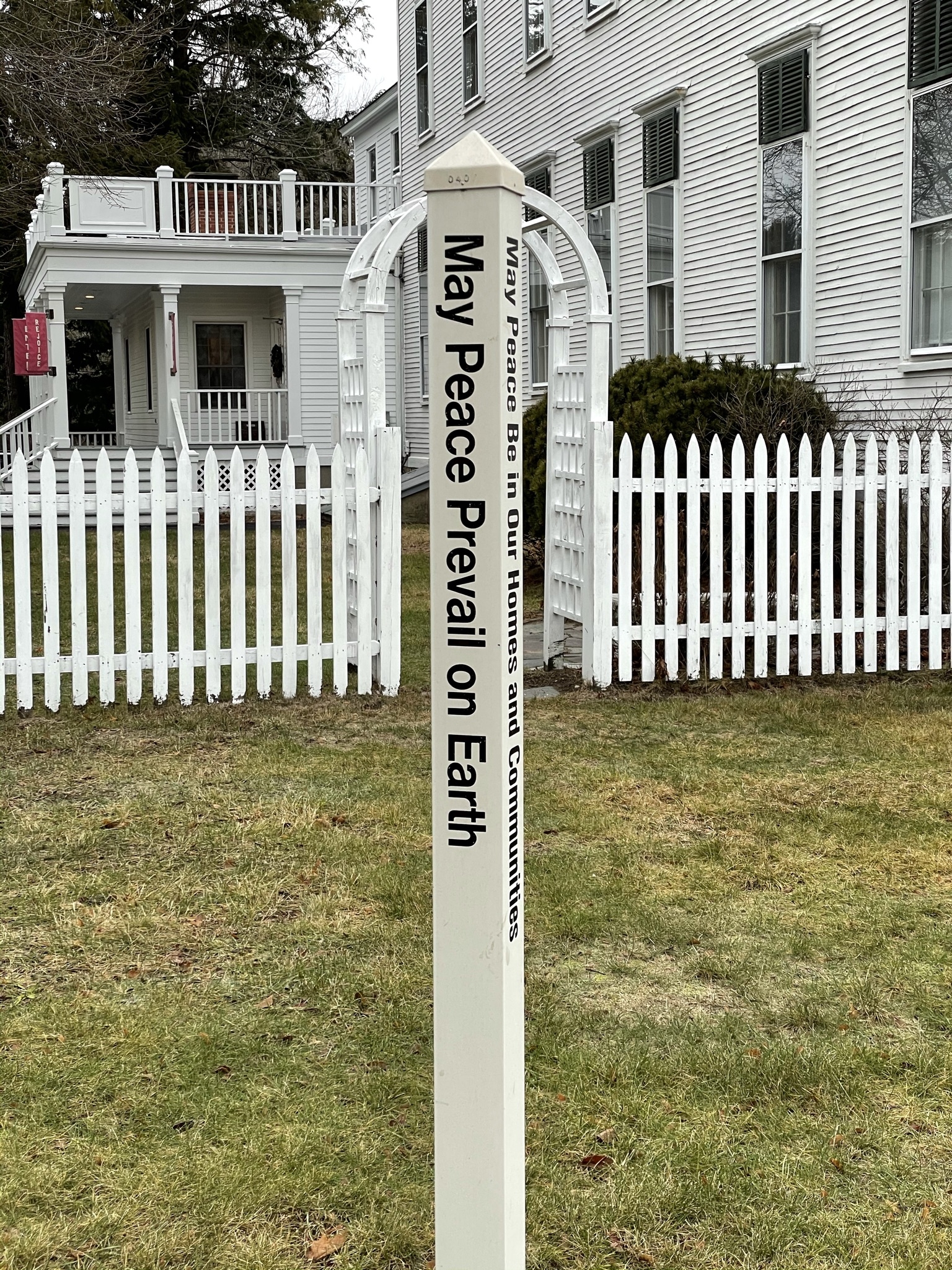 The post on the lawn which reads "May peace prevail on Earth"