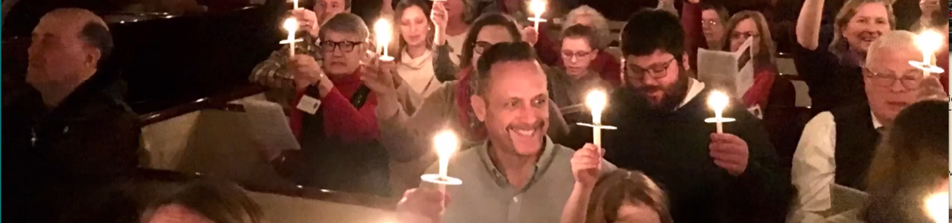 A xmas ritual in the sanctuary holding candles during a service